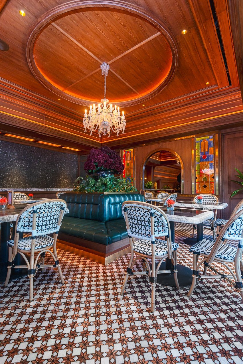 Elegant restaurant interior with chandelier, patterned chairs, and wooden decor for a luxurious dining experience.